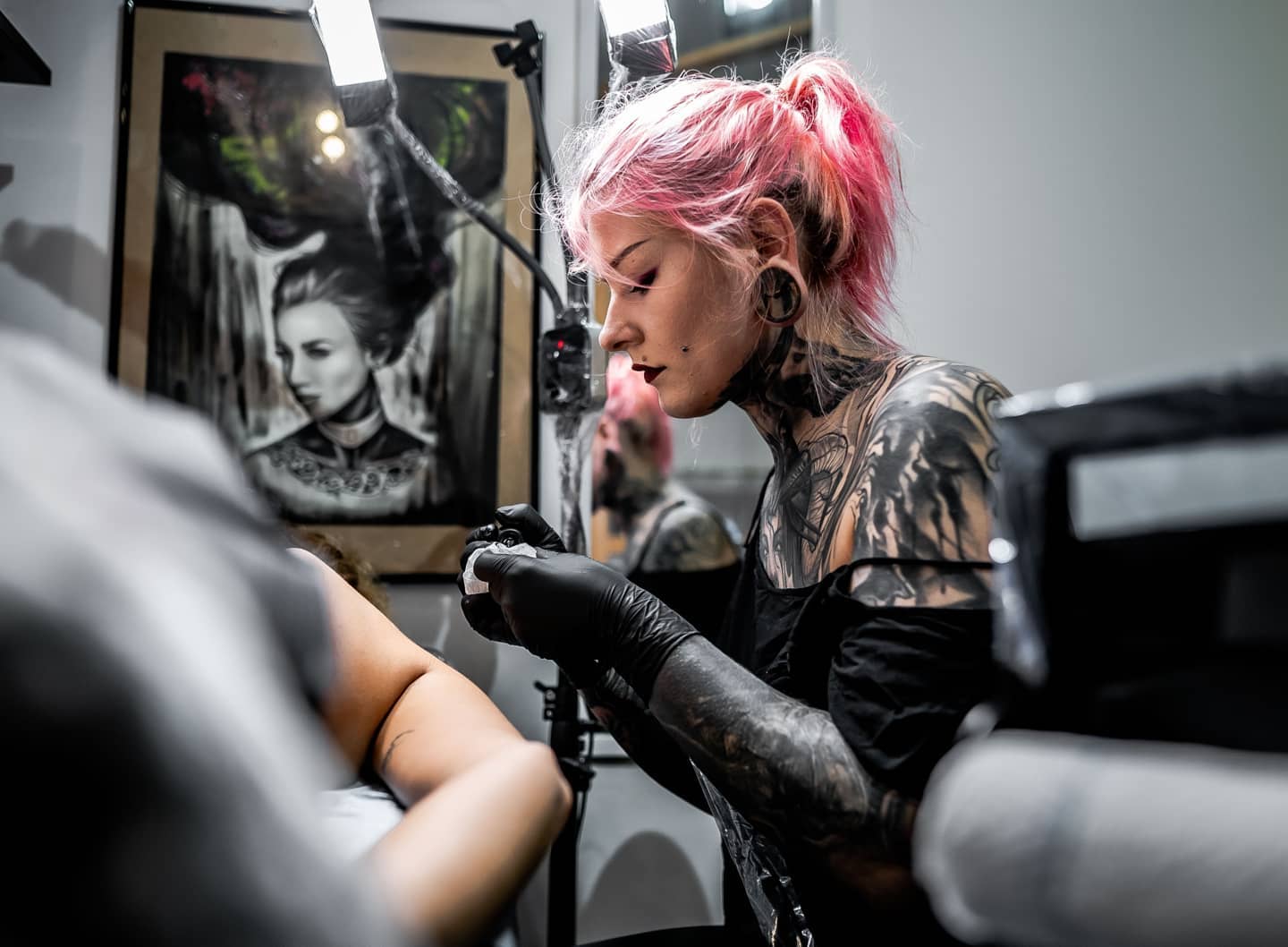 MadMeow tattooing a client in her studio in Latvia